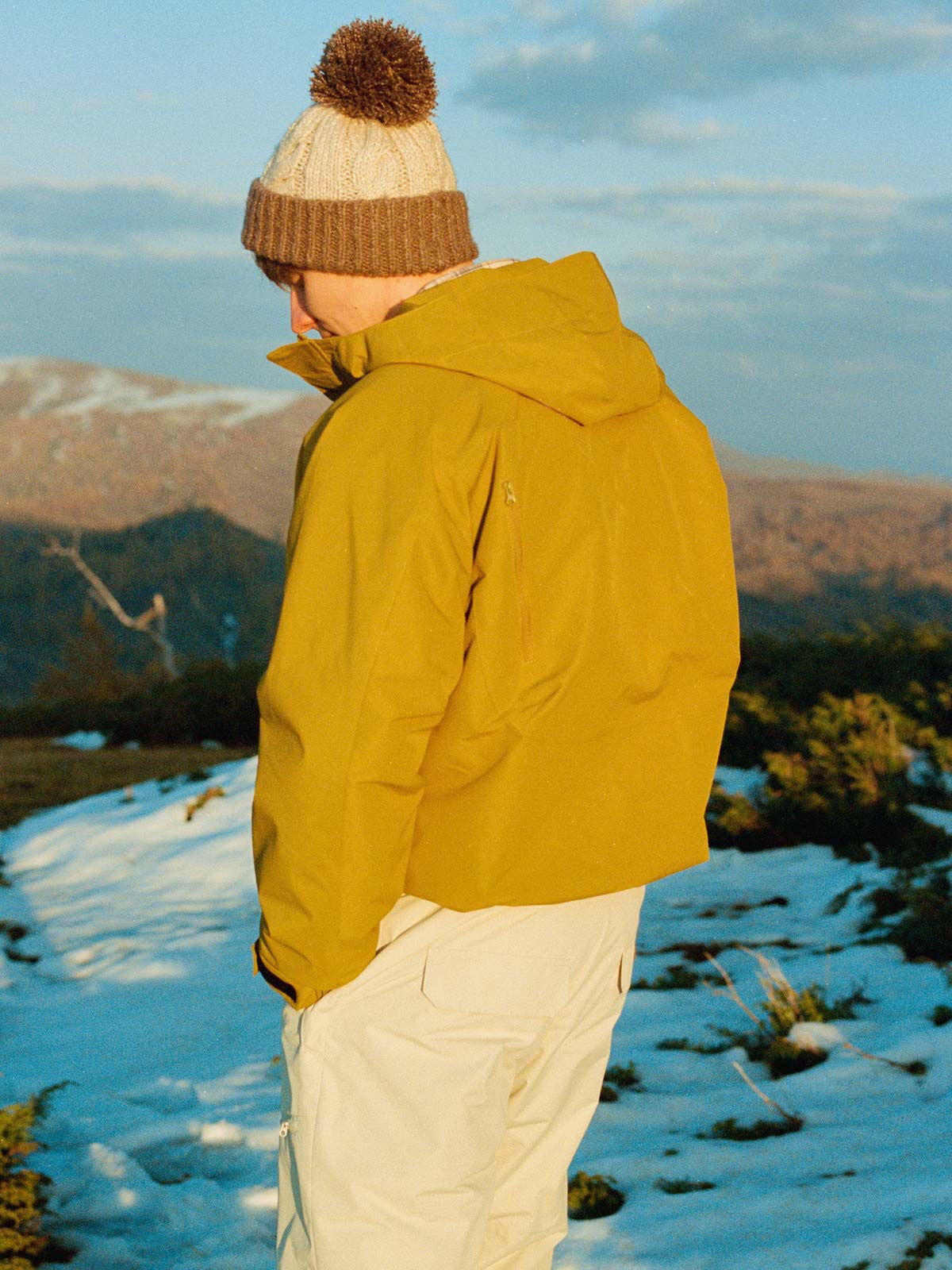 詳細画像: フロントの大きなポケットと背面ジップポケットのディテール展示 - 実用的な収納スペースが魅力。
モデル画像: モデル着用のアウトドアワークスタイルシェルジャケット - アウトドアや日常使いに活躍するスタイリング。