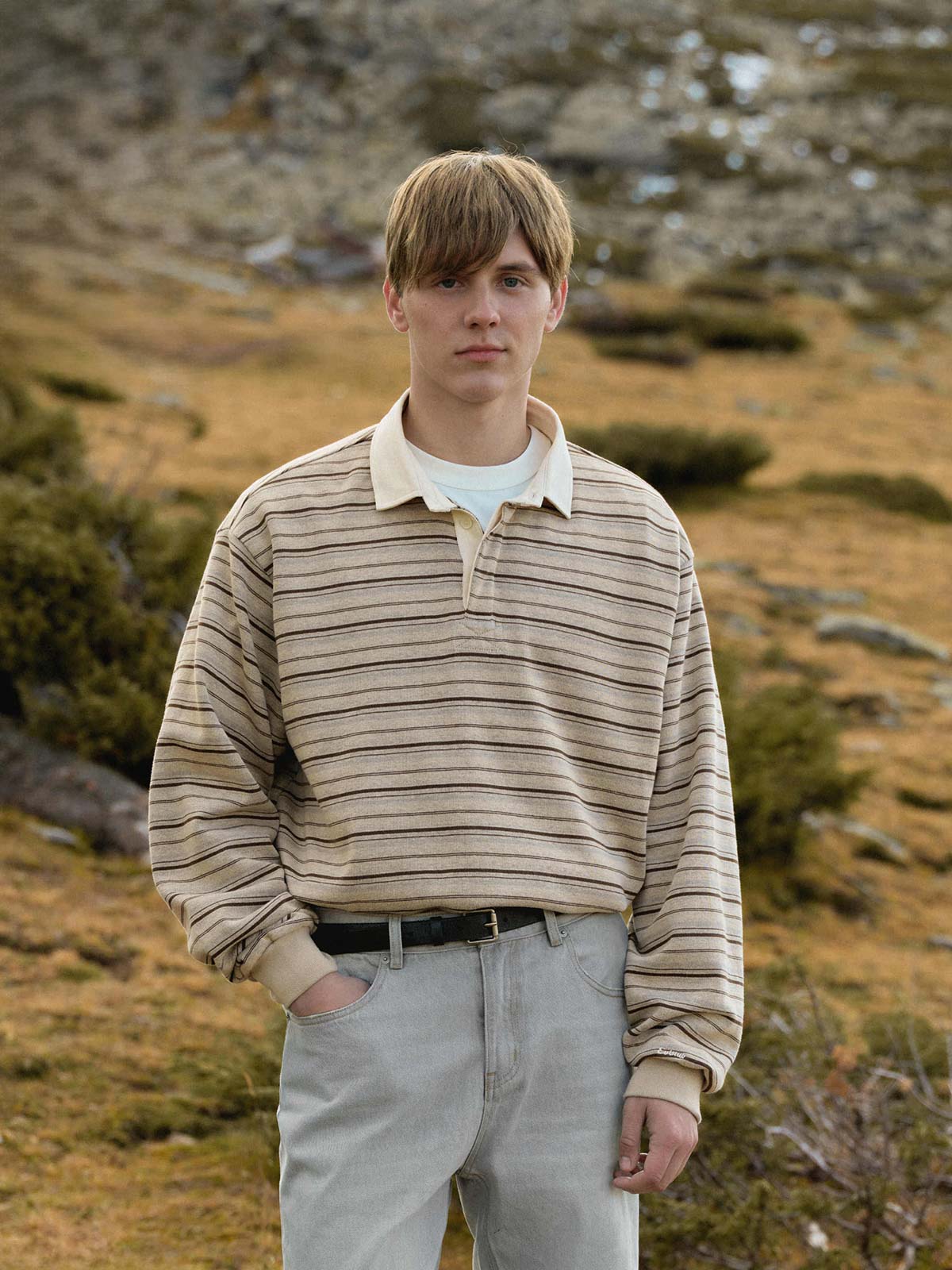 詳細画像: バイカラーストライプとクラシックな襟のディテール
モデル画像: モデルが着用する秋冬向けレトロスタイルのバイカラーストライプニットポロシャツ