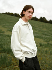 詳細画像: ハーフジップディテールとスタンドカラー部分のクローズアップ。しっかりとした手触りと滑らかな表面感を持つ高品質コットンポリエステル混紡素材のディテールにフォーカス。
モデル画像: モデルがハーフジップ スタンドカラー スウェットとデニムを合わせ、クラシックなアメカジスタイルを披露。コーディネートの多様性を強調し、通勤やカジュアルシーンにも適した着こなし。