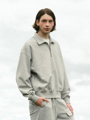 詳細画像: ハーフジップディテールとスタンドカラー部分のクローズアップ。しっかりとした手触りと滑らかな表面感を持つ高品質コットンポリエステル混紡素材のディテールにフォーカス。
モデル画像: モデルがハーフジップ スタンドカラー スウェットとデニムを合わせ、クラシックなアメカジスタイルを披露。コーディネートの多様性を強調し、通勤やカジュアルシーンにも適した着こなし。