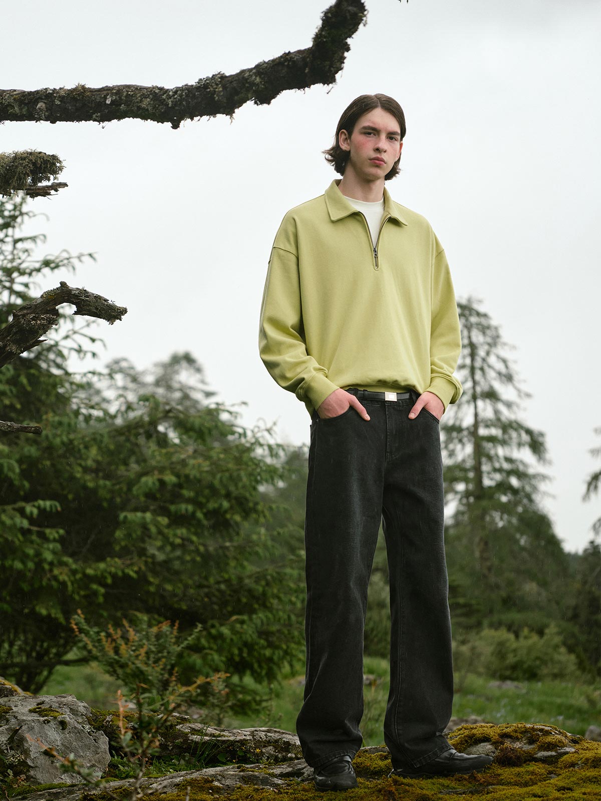 詳細画像: ハーフジップディテールとスタンドカラー部分のクローズアップ。しっかりとした手触りと滑らかな表面感を持つ高品質コットンポリエステル混紡素材のディテールにフォーカス。
モデル画像: モデルがハーフジップ スタンドカラー スウェットとデニムを合わせ、クラシックなアメカジスタイルを披露。コーディネートの多様性を強調し、通勤やカジュアルシーンにも適した着こなし。