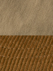 キャップのエラスティックバンド固定デザインと低彩度オレンジ色のバッジのクローズアップ。