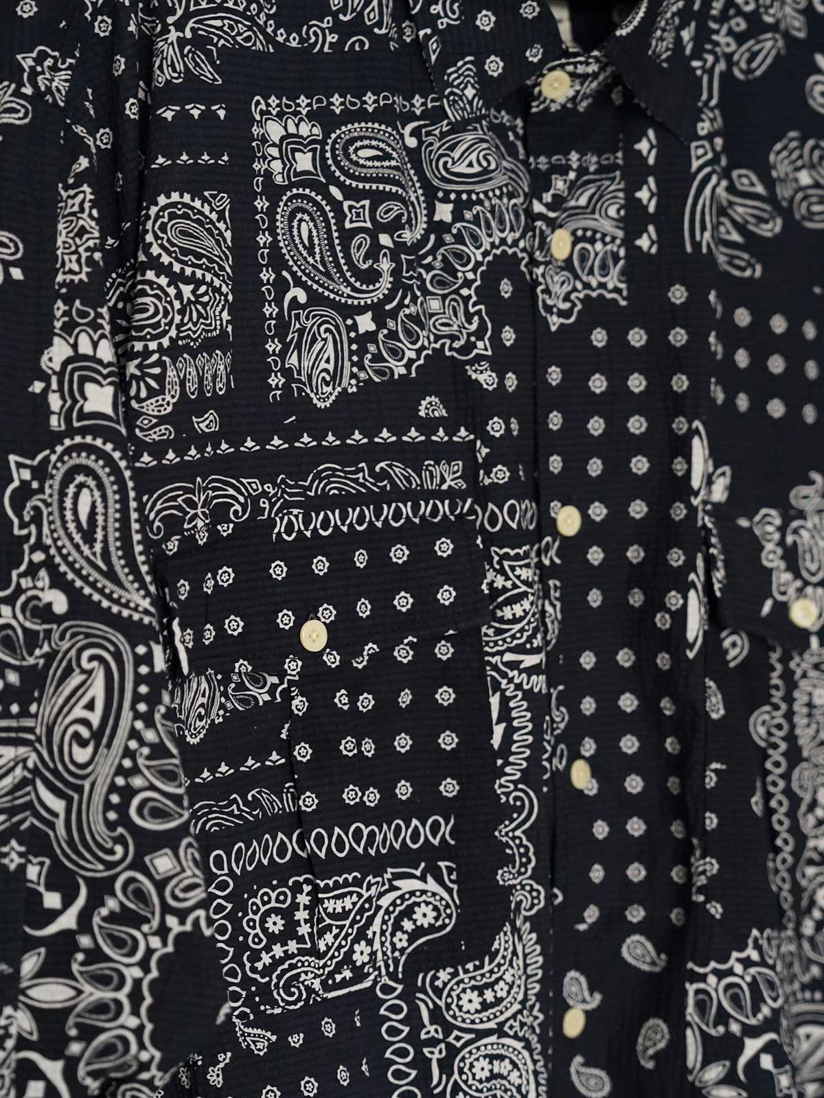 製品画像
ペイズリー柄シアサッカーシャツの正面デザイン。アメリカンバンダナ文化を反映した不規則なプリントパターンと、軽量で通気性の高いシアサッカー生地が特徴
詳細画像
3つのポケットと独特なシワ感を持つシアサッカー生地のディテール。18針/3cmの高密度縫製工法による精密な仕上がりが際立つ