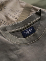 製品画像
ヴィンテージ蝋染めスウェットシャツ正面デザイン。グレイッシュグリーンやデニムブルーなどの植物染料で仕上げた深みのある色合いと、ルーズフィットのシルエットが特徴。日本伝統の蝋染め技法によるユニークな色彩表現が際立つ一着
詳細画像
ネックライン周辺の精密な3cmあたり18針ステッチと、蝋染め加工で生まれる独特な色彩の層次感を特写。二重構造の肩テープとサイドステッチのディテールが、耐久性と快適な着心地を提供する仕上がり