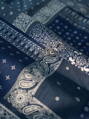 製品画像
藍染めバンダナ柄フライトジャケットの正面デザイン。匠の技による藍染め技法で仕上げられたペイズリー柄が特徴で、二重構造のスタンドカラーとルーズフィットのシルエットが現代的なミリタリースタイルを演出
詳細画像
YKK樹脂製ダブルジッパーの刺し子柄ジッパープルと、マジックテープ部分に施された高密度刺繍の特写。繊細なディテールと藍染め技術による色の濃淡が際立つデザイン