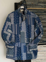 製品画像
藍染めバンダナ柄フライトジャケットの正面デザイン。匠の技による藍染め技法で仕上げられたペイズリー柄が特徴で、二重構造のスタンドカラーとルーズフィットのシルエットが現代的なミリタリースタイルを演出
詳細画像
YKK樹脂製ダブルジッパーの刺し子柄ジッパープルと、マジックテープ部分に施された高密度刺繍の特写。繊細なディテールと藍染め技術による色の濃淡が際立つデザイン