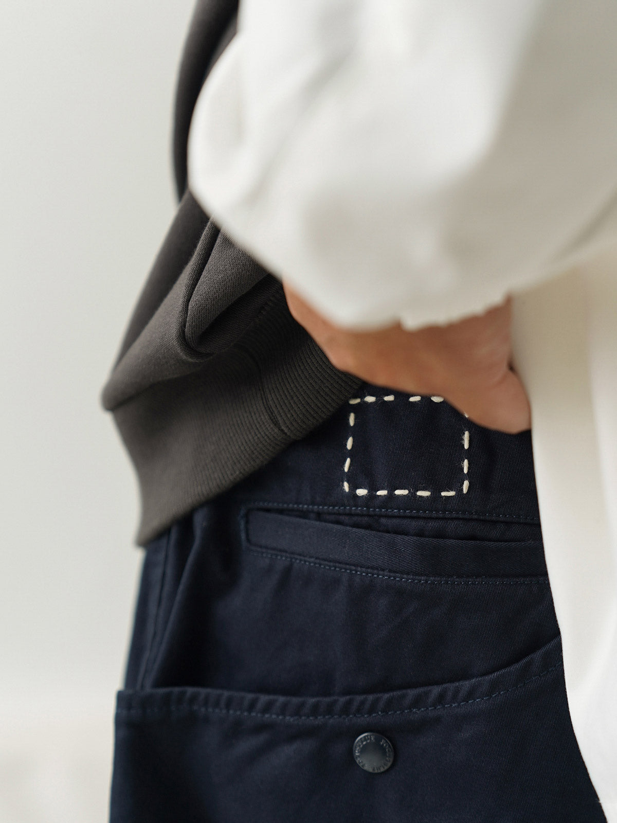 詳細画像
「非対称の刺し子刺繍ディテールと大容量の弧形ポケットをクローズアップ。膝部分の左右異なる刺繍パターンが立体感を強調。」
モデル画像
「カジュアルなトップスと組み合わせたハンド刺し子テーパードパンツ。テーパードシルエットが美しい脚のラインを演出し、モダンで伝統的なスタイルを体現。」