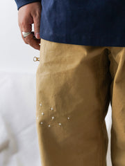 詳細画像
「非対称の刺し子刺繍ディテールと大容量の弧形ポケットをクローズアップ。膝部分の左右異なる刺繍パターンが立体感を強調。」
モデル画像
「カジュアルなトップスと組み合わせたハンド刺し子テーパードパンツ。テーパードシルエットが美しい脚のラインを演出し、モダンで伝統的なスタイルを体現。」