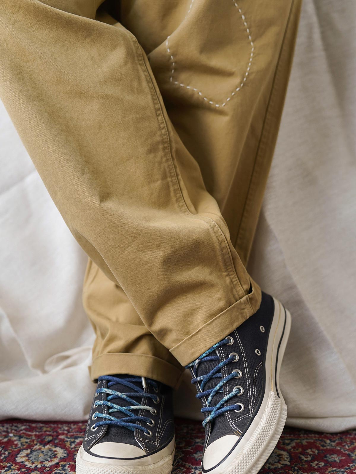 詳細画像
「非対称の刺し子刺繍ディテールと大容量の弧形ポケットをクローズアップ。膝部分の左右異なる刺繍パターンが立体感を強調。」
モデル画像
「カジュアルなトップスと組み合わせたハンド刺し子テーパードパンツ。テーパードシルエットが美しい脚のラインを演出し、モダンで伝統的なスタイルを体現。」