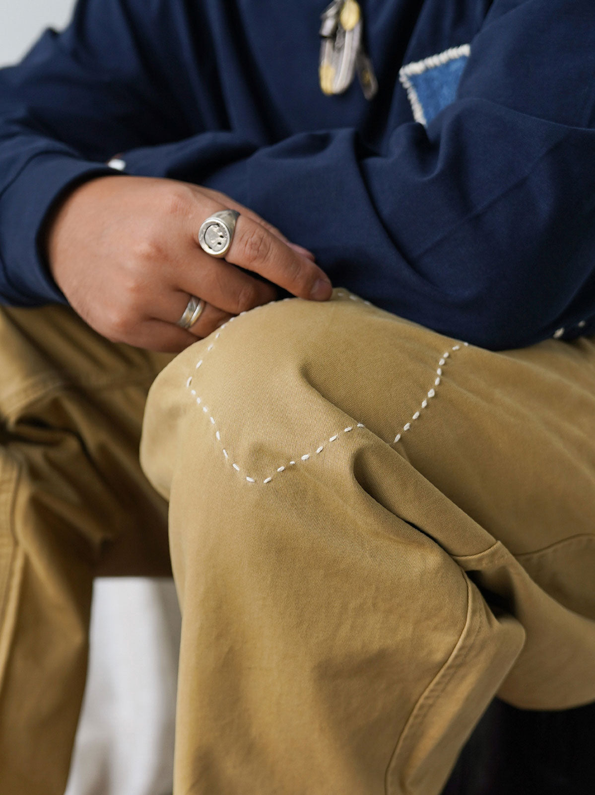 詳細画像
「非対称の刺し子刺繍ディテールと大容量の弧形ポケットをクローズアップ。膝部分の左右異なる刺繍パターンが立体感を強調。」
モデル画像
「カジュアルなトップスと組み合わせたハンド刺し子テーパードパンツ。テーパードシルエットが美しい脚のラインを演出し、モダンで伝統的なスタイルを体現。」