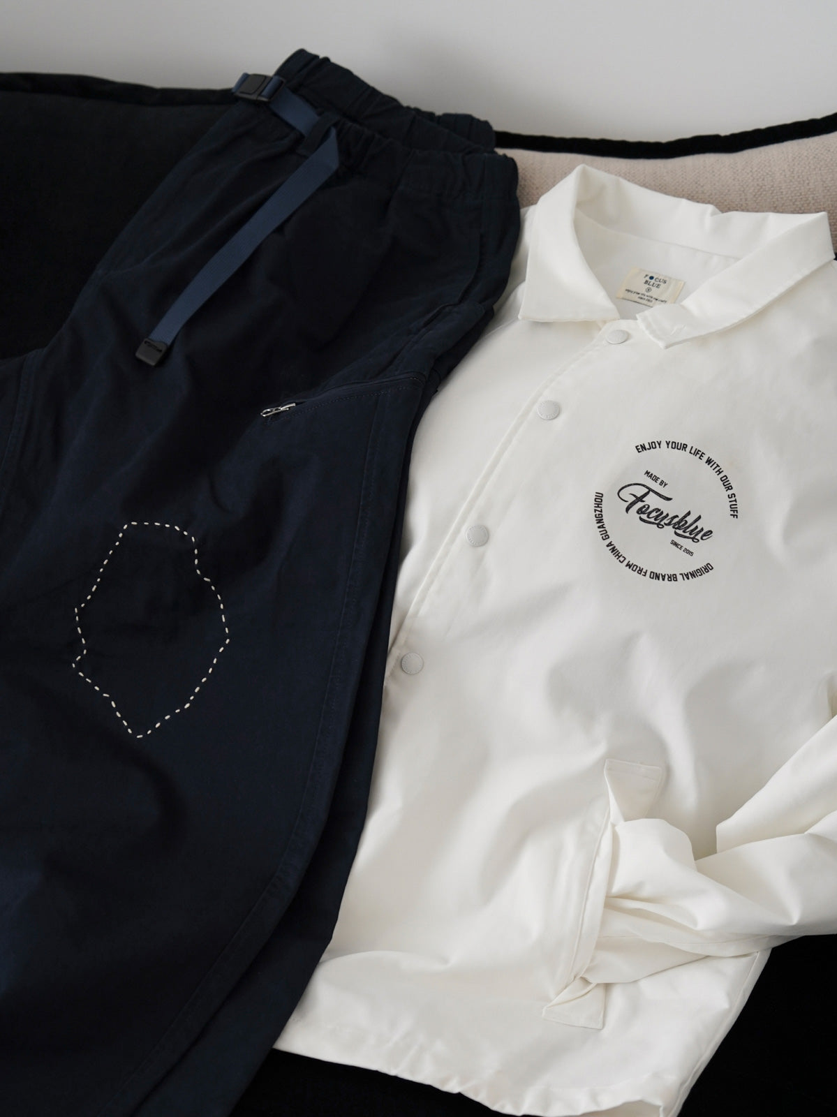 製品画像
「刺し子の伝統工芸を取り入れたハンド刺し子テーパードパンツ全体イメージ。高密度磨毛コットンツイル生地を使用し、快適さと耐久性を兼ね備えたデザイン。」
詳細画像
「非対称の刺し子刺繍ディテールと大容量の弧形ポケットをクローズアップ。膝部分の左右異なる刺繍パターンが立体感を強調。」