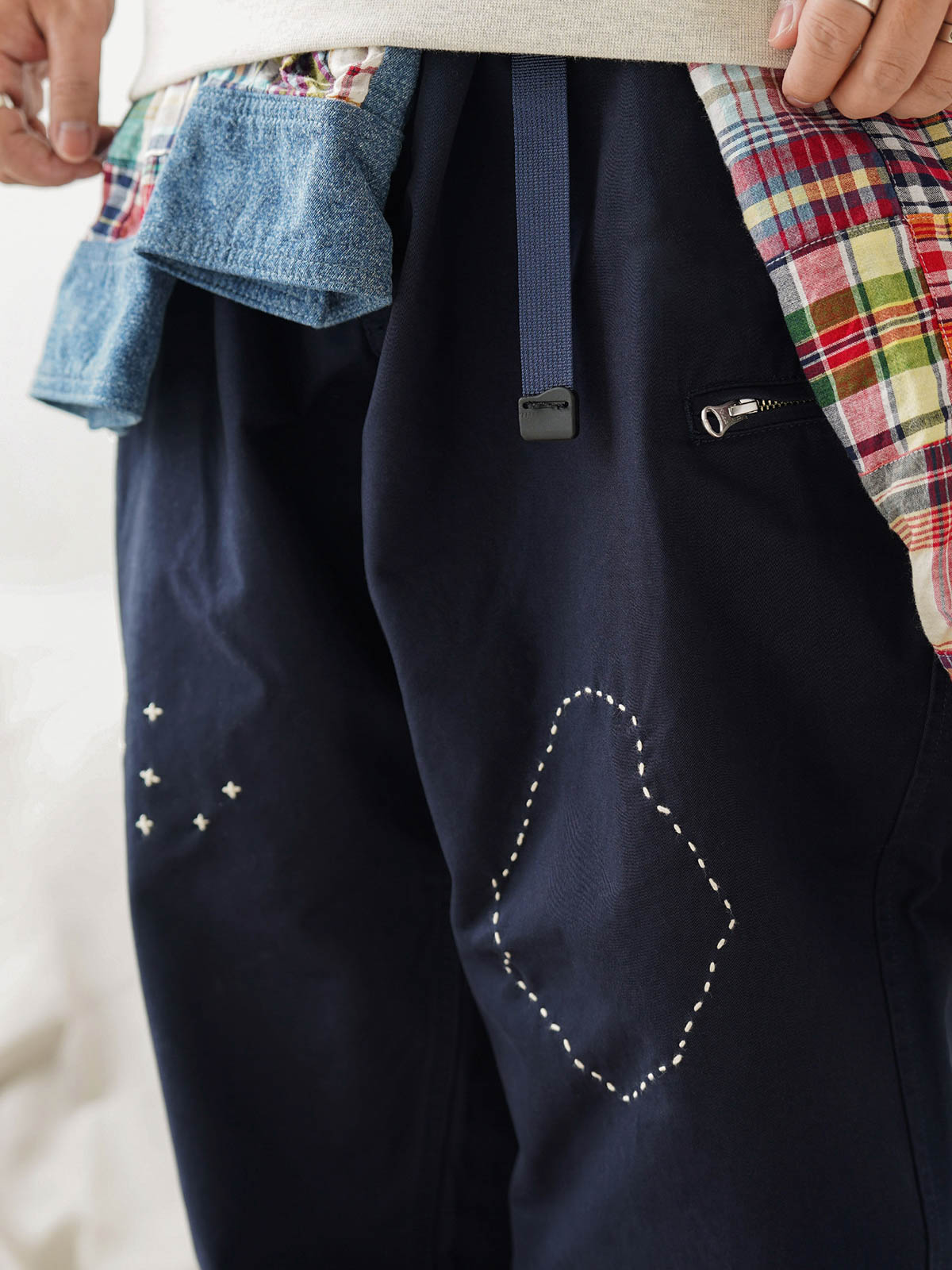 詳細画像
「非対称の刺し子刺繍ディテールと大容量の弧形ポケットをクローズアップ。膝部分の左右異なる刺繍パターンが立体感を強調。」
モデル画像
「カジュアルなトップスと組み合わせたハンド刺し子テーパードパンツ。テーパードシルエットが美しい脚のラインを演出し、モダンで伝統的なスタイルを体現。」