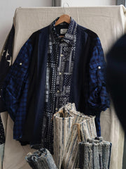 製品画像
「REMAKE パッチワーク アシンメトリーヘム 長袖シャツの正面全体図。藍染め織りのチェック柄、ペイズリー柄、デニム、コーデュロイなど、異素材を組み合わせたブルー系デザインが特徴で、分解・再構築のリメイクスタイルを採用した個性的なシャツ。」
詳細画像
「REMAKE パッチワーク アシンメトリーヘム 長袖シャツの素材ディテール特写。藍染め織りのチェック柄やペイズリー柄、デニム、コーデュロイなど6種類の異素材を組み合わせたパッチワークと、動きのあるアシンメトリーヘムのクローズアップ。袖部分には調節可能なタブも配置。」