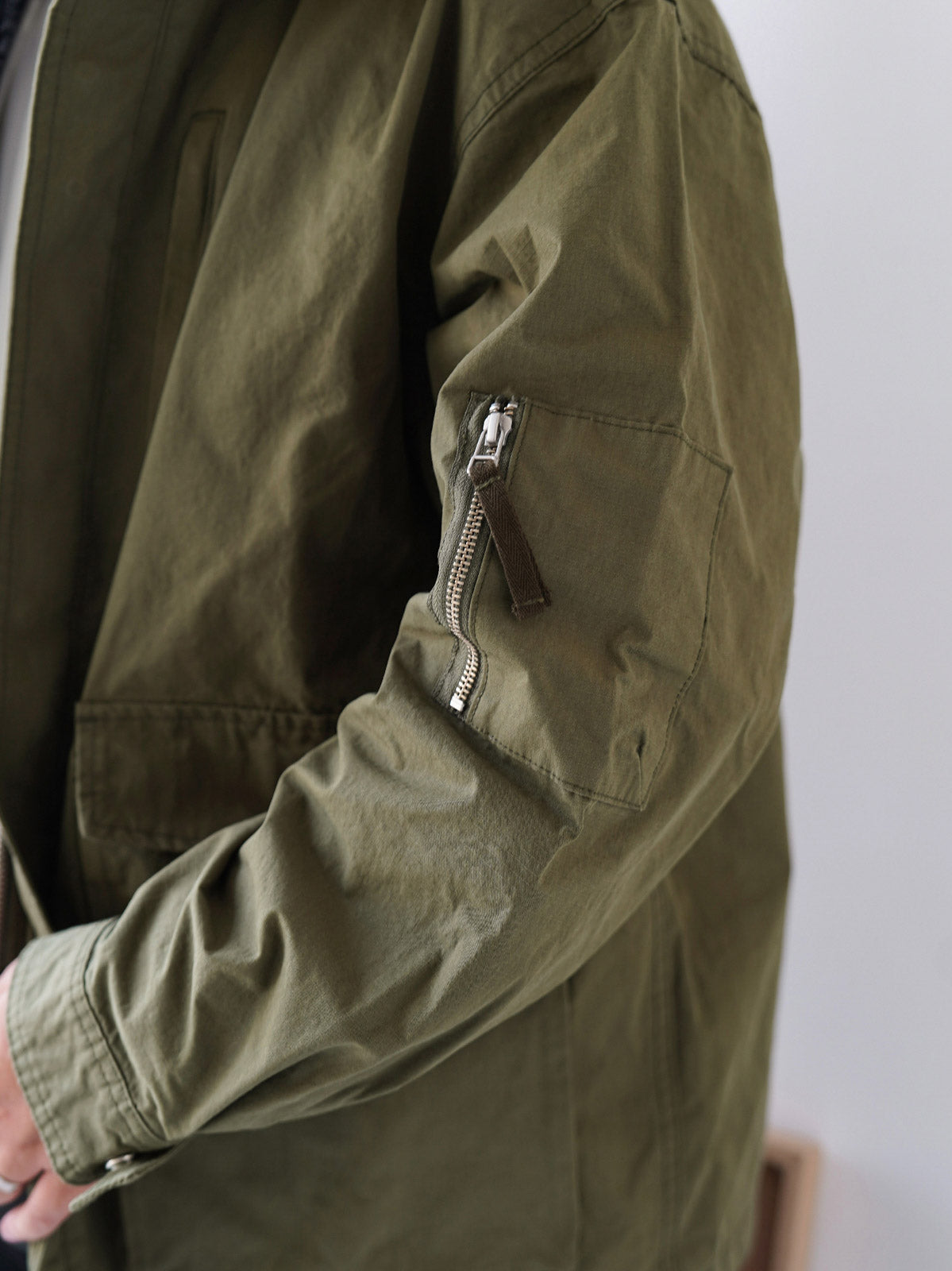 詳細画像
「ハードシェルのような質感を持つチェック柄ファブリックとペイズリー柄コットン裏地、隠しジップポケットや大型スナップボタンのディテールクローズアップ。」
モデル画像
「モデルがヴィンテージ風 通勤用 トレンチジャケットを着用し、大容量ポケットとルーズフィットシルエットで快適さとスタイリッシュさを両立した通勤コーディネート。」