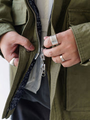 詳細画像
「ハードシェルのような質感を持つチェック柄ファブリックとペイズリー柄コットン裏地、隠しジップポケットや大型スナップボタンのディテールクローズアップ。」
モデル画像
「モデルがヴィンテージ風 通勤用 トレンチジャケットを着用し、大容量ポケットとルーズフィットシルエットで快適さとスタイリッシュさを両立した通勤コーディネート。」