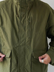 詳細画像
「ハードシェルのような質感を持つチェック柄ファブリックとペイズリー柄コットン裏地、隠しジップポケットや大型スナップボタンのディテールクローズアップ。」
モデル画像
「モデルがヴィンテージ風 通勤用 トレンチジャケットを着用し、大容量ポケットとルーズフィットシルエットで快適さとスタイリッシュさを両立した通勤コーディネート。」