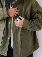 詳細画像
「ハードシェルのような質感を持つチェック柄ファブリックとペイズリー柄コットン裏地、隠しジップポケットや大型スナップボタンのディテールクローズアップ。」
モデル画像
「モデルがヴィンテージ風 通勤用 トレンチジャケットを着用し、大容量ポケットとルーズフィットシルエットで快適さとスタイリッシュさを両立した通勤コーディネート。」