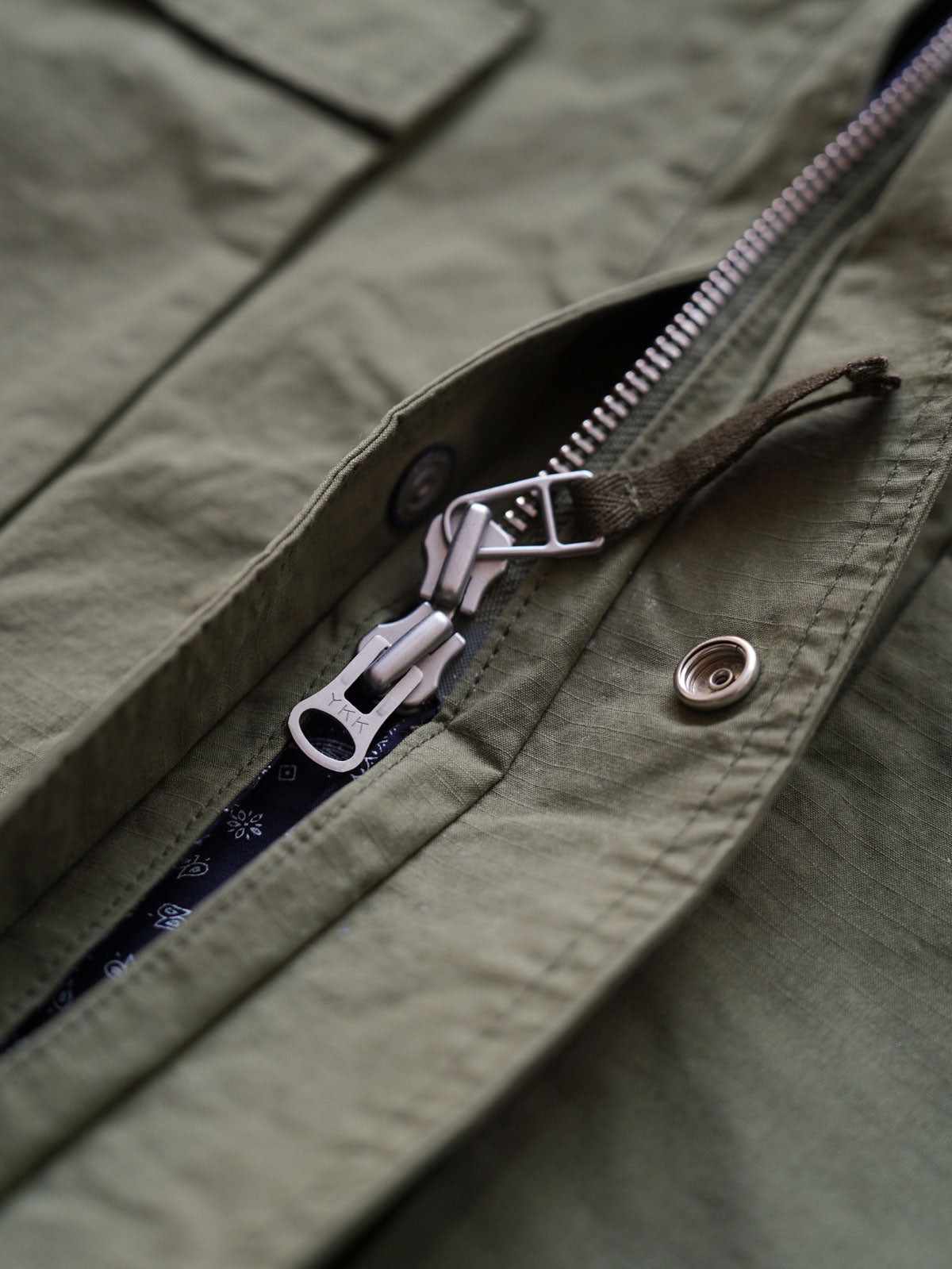 製品画像
「ヴィンテージ風 通勤用 トレンチジャケット全体イメージ。コーティング加工のチェック柄ファブリックとペイズリー柄コットン裏地が特徴の多機能デザイン。」
詳細画像
「ハードシェルのような質感を持つチェック柄ファブリックとペイズリー柄コットン裏地、隠しジップポケットや大型スナップボタンのディテールクローズアップ。」