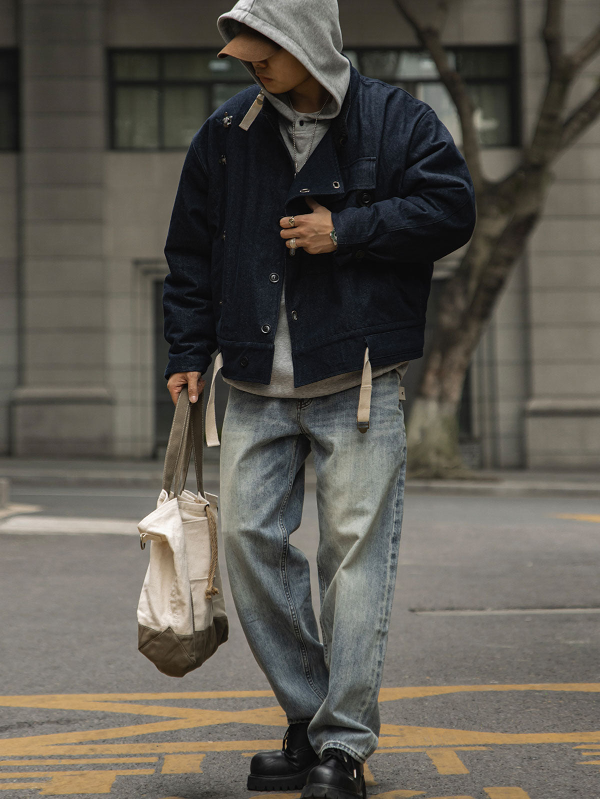 詳細画像
デッキフックとスウェードラベルのディテールクローズアップ。海軍スタイルのボタンとレトロなデザインがミリタリー感を際立たせる。
モデル画像
モデルが着用したレトロなバイカージャケットの冬のスタイル展示。デニムとワークブーツとの相性が抜群で、硬派な冬のコーディネートが完成。