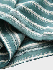 Tシャツの調節可能なドローストリング襟のクローズアップ。詳細なステッチとストライプパターンが特徴。