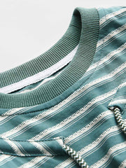 Tシャツの調節可能なドローストリング襟のクローズアップ。詳細なステッチとストライプパターンが特徴。