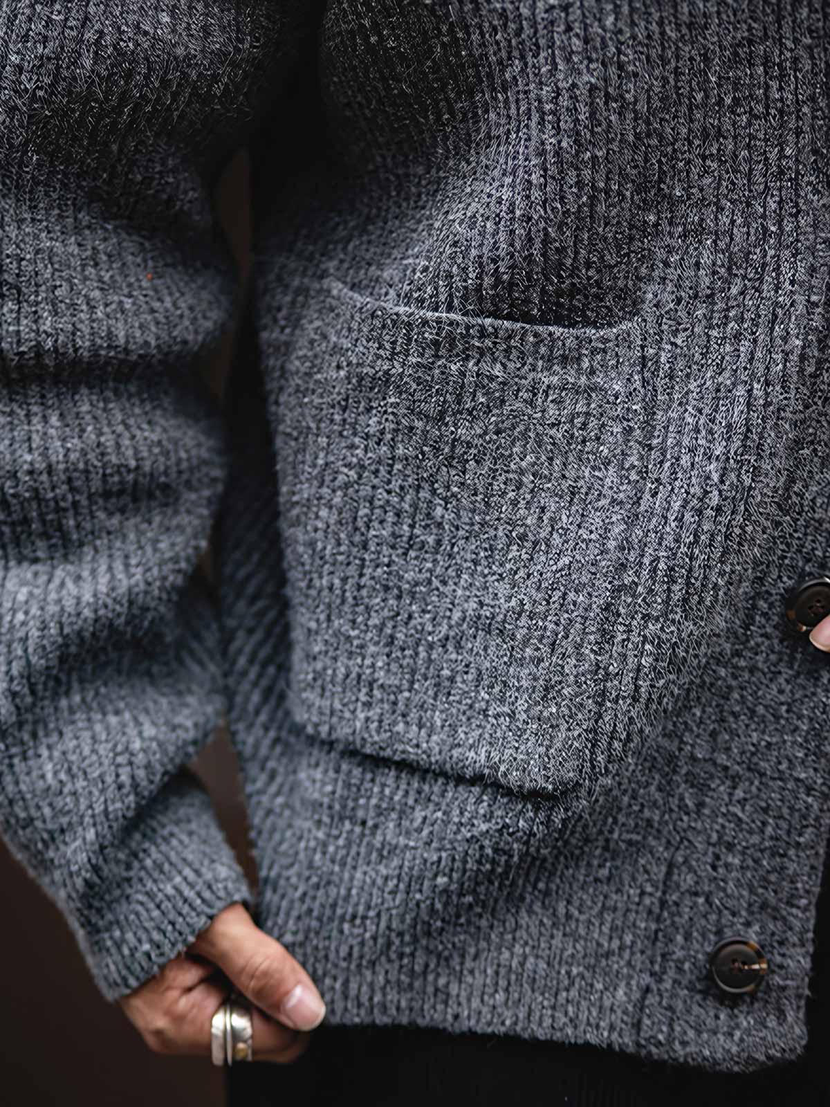 製品画像
加厚メリノウールを使用したニットカーディガンの全体展示。柔らかく暖かいメリノウール混紡素材を採用し、冬に最適な保温性と耐久性を兼ね備えた厚手デザインが特徴。
詳細画像
ニットカーディガンのリブ編みディテールとブランドカスタム「ジェントルマン」デザインを特写。型崩れしにくいリブ編み技術と高級感あふれるディテールが際立つクローズアップ画像。