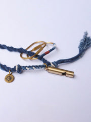 ブルーダイブレードネックレスの細部とサバイバルホイッスルペンダントのクローズアップ。