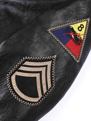 製品画像
「リバイバルデザインのミリタリー レザージャケット正面ショット。WWII時代のタンクジャケットを再現したショート丈仕様で動きやすさとクラシックなミリタリースタイルを融合。」
詳細画像
「高品質PUレザーの細やかな質感をクローズアップ。袖の軍章と部隊マーク、リブ仕様の袖口でミリタリーの魅力を表現。」