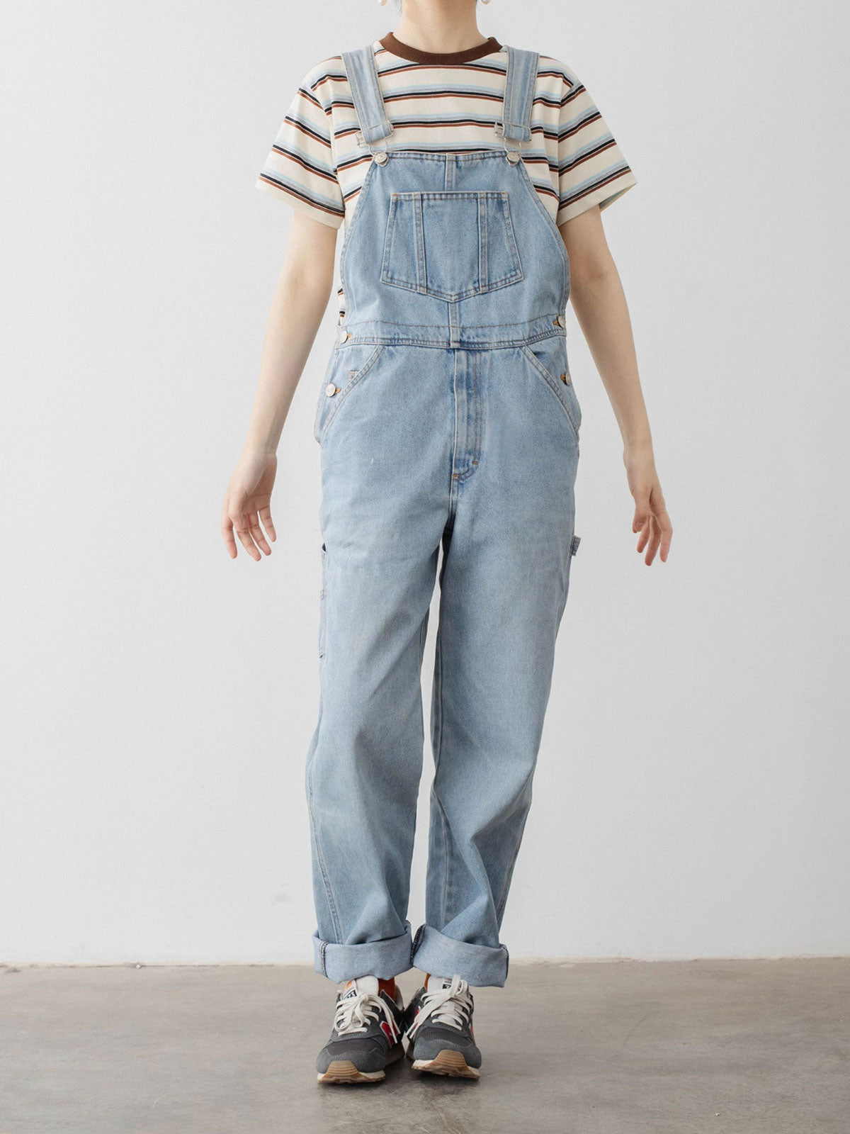 モデルがPESSOA CLUBのカラーブロックストライプTシャツを着用し、ダイナミックなカジュアルスタイルを披露