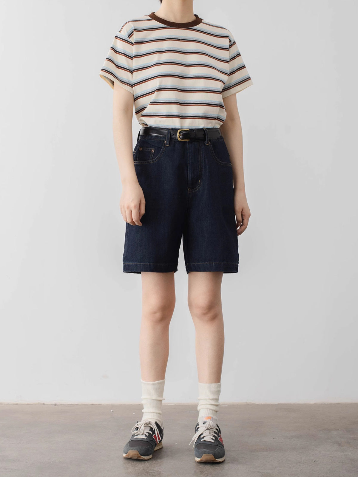 モデルがPESSOA CLUBのカラーブロックストライプTシャツを着用し、ダイナミックなカジュアルスタイルを披露