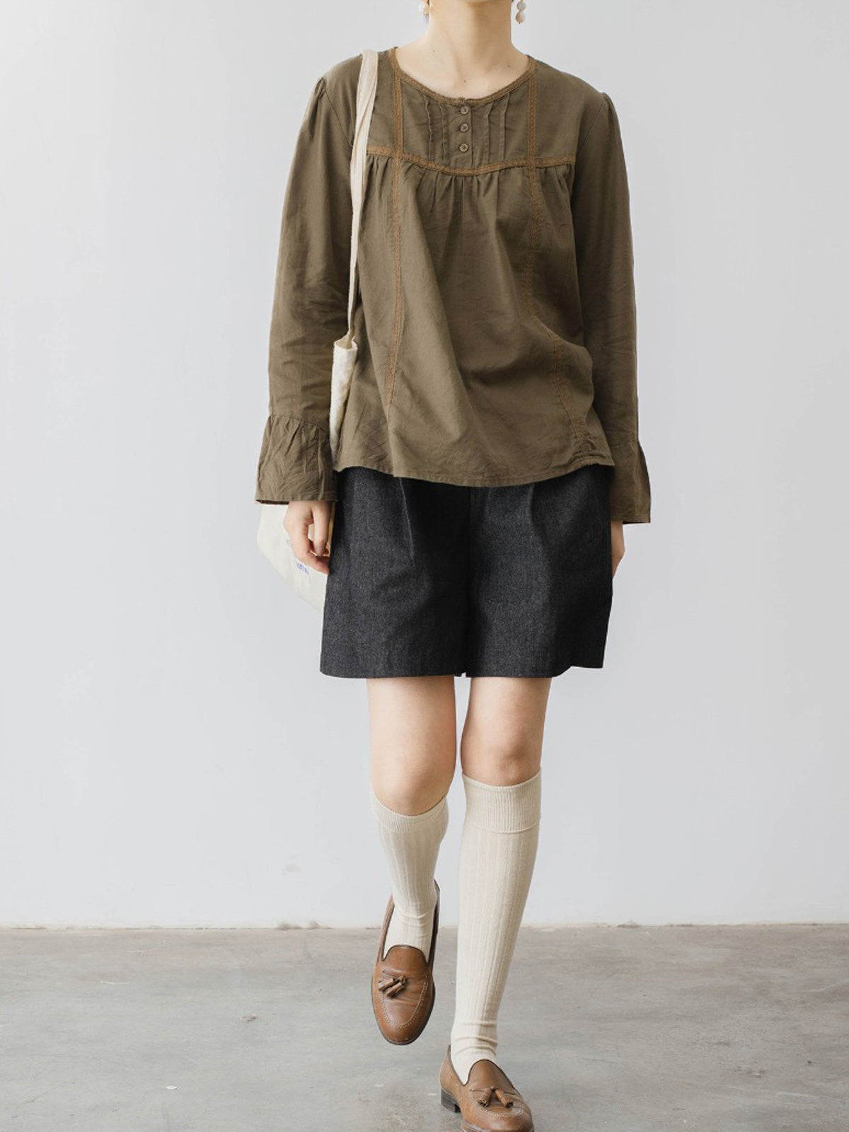 モデルがハイウエストデニムショートパンツを着用し、スタイリッシュなシルエットを披露