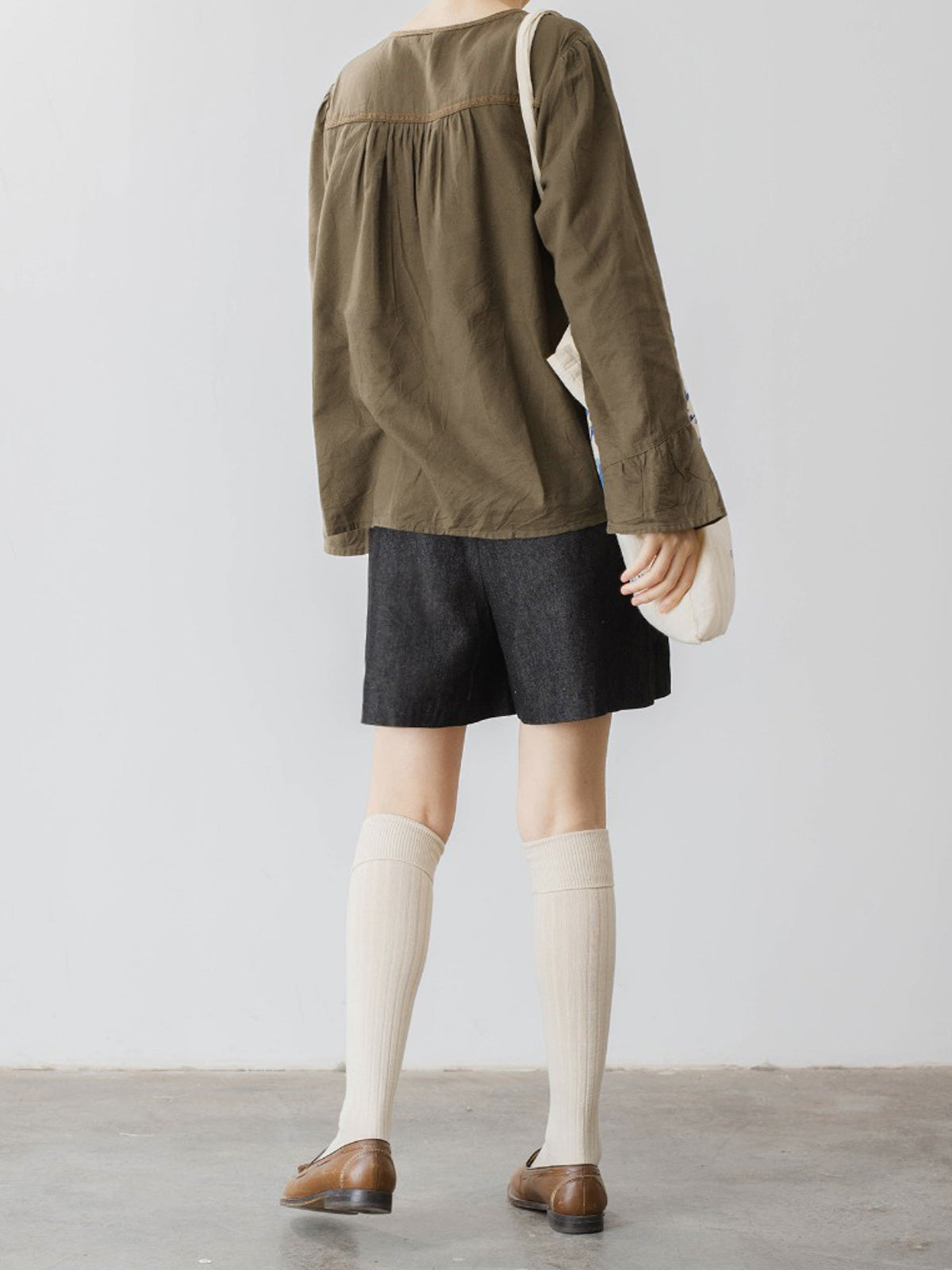 モデルがハイウエストデニムショートパンツを着用し、スタイリッシュなシルエットを披露