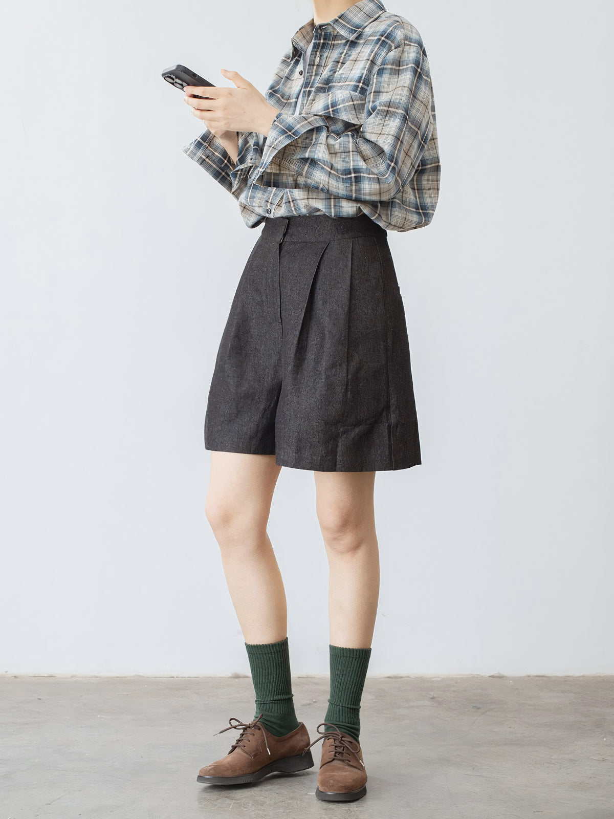 モデルがハイウエストデニムショートパンツを着用し、スタイリッシュなシルエットを披露