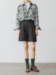 モデルがハイウエストデニムショートパンツを着用し、スタイリッシュなシルエットを披露