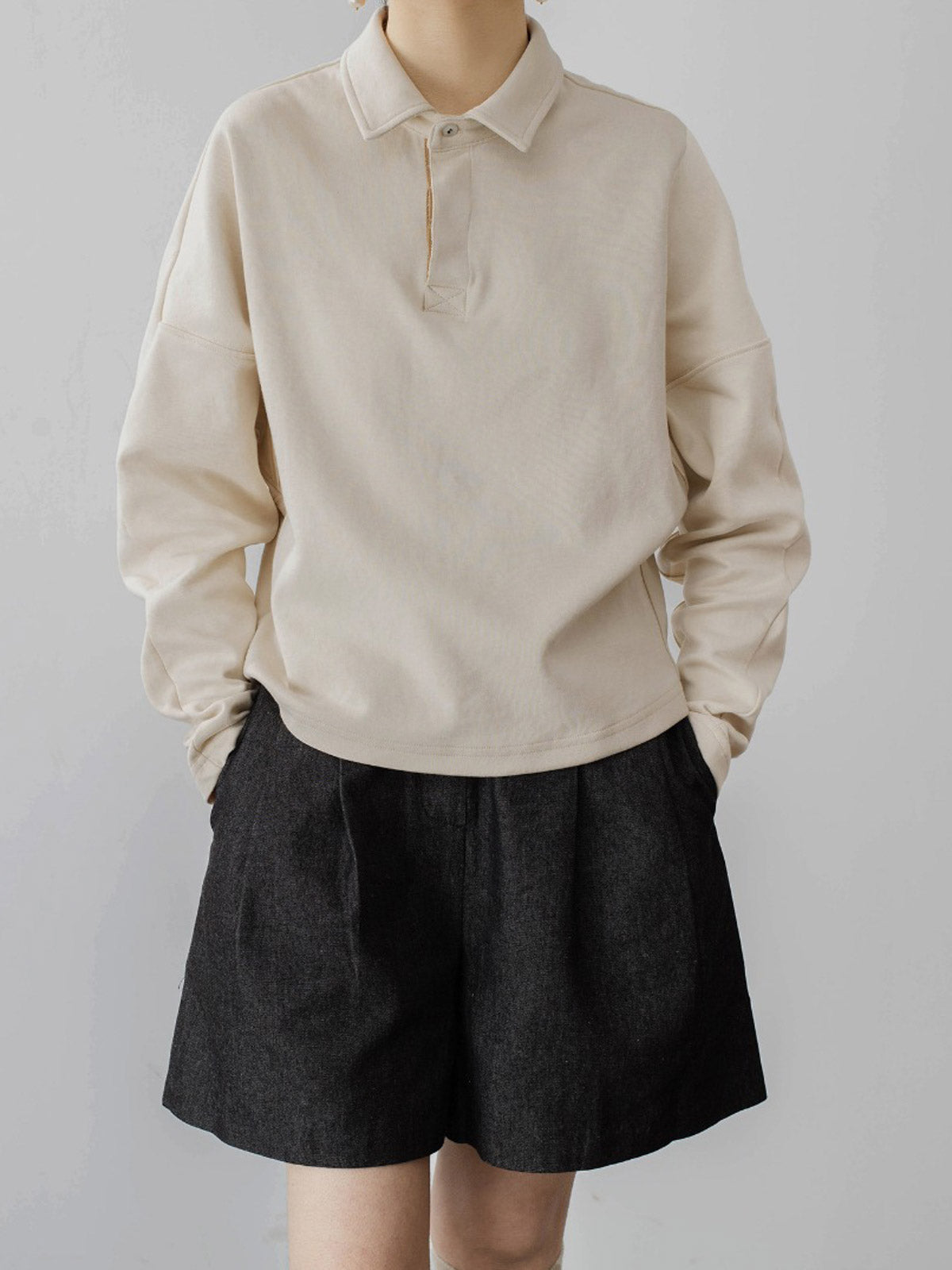 モデルがハイウエストデニムショートパンツを着用し、スタイリッシュなシルエットを披露