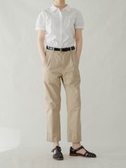 モデルが白色ピーターパンカラーシャツを着用し、シックなスタイルを披露