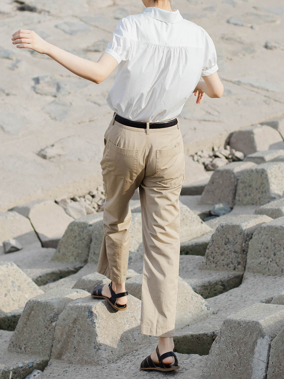 モデルが白色ピーターパンカラーシャツを着用し、シックなスタイルを披露