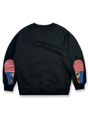 製品画像: ドロップ型肘パッチスウェット全体展示図。380gの厚手コットン素材を使用し、ヴィンテージ感とアート性が際立つデザイン。
詳細画像: 肘部分に施されたドロップ型パッチワークディテールの特写。コントラストの効いた配色とヴィンテージ風の装飾がポイント。