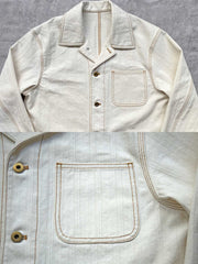 製品画像:
アイボリーヘリンボーン織りのワークジャケット全体画像。クラシックで高級感あるデザイン。
詳細画像:
コントラストステッチのディテール。精巧な縫製がジャケットの魅力を引き立てます。