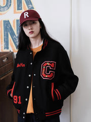 詳細画像:
刺繍アルファベットとリブ編みのストライプディテールのクローズアップ。ヴィンテージ感のあるデザインがアメリカンキャンパススタイルを強調しています。
モデル画像:
モデルがスタジャンを着用し、デニムと合わせてアメリカンキャンパススタイルを演出。クラシックなヴィンテージ感が現代のストリートスタイルにもぴったりです。