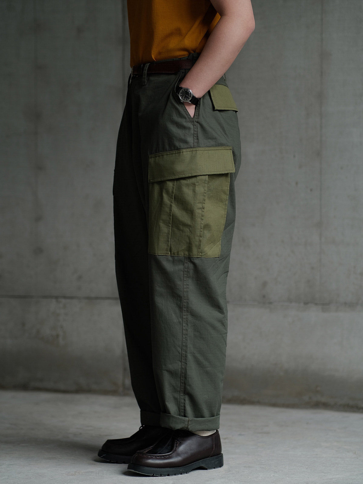 詳細画像: ワークパンツの大きなパネルポケットとドローストリングのディテール
モデル画像: ワークパンツの着用イメージ、日常使いに最適なカジュアルスタイル