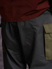 詳細画像: ワークパンツの大きなパネルポケットとドローストリングのディテール
モデル画像: ワークパンツの着用イメージ、日常使いに最適なカジュアルスタイル