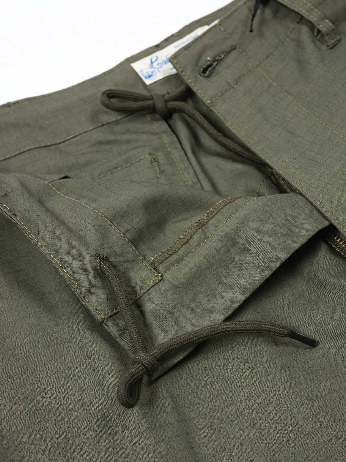 製品画像: パネルポケット付きワークパンツ全体画像、ルーズフィットデザインとドローストリング調節可能
詳細画像: ワークパンツの大きなパネルポケットとドローストリングのディテール