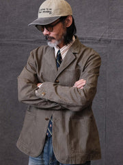 詳細画像: ウォッシュ加工されたヘリンボーン柄の生地とヴィンテージメタルボタンのディテール
モデル画像: ゆるやかなフィットでスタイリッシュなヴィンテージウォッシュジャケットの着用イメージ