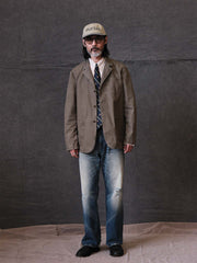 詳細画像: ウォッシュ加工されたヘリンボーン柄の生地とヴィンテージメタルボタンのディテール
モデル画像: ゆるやかなフィットでスタイリッシュなヴィンテージウォッシュジャケットの着用イメージ