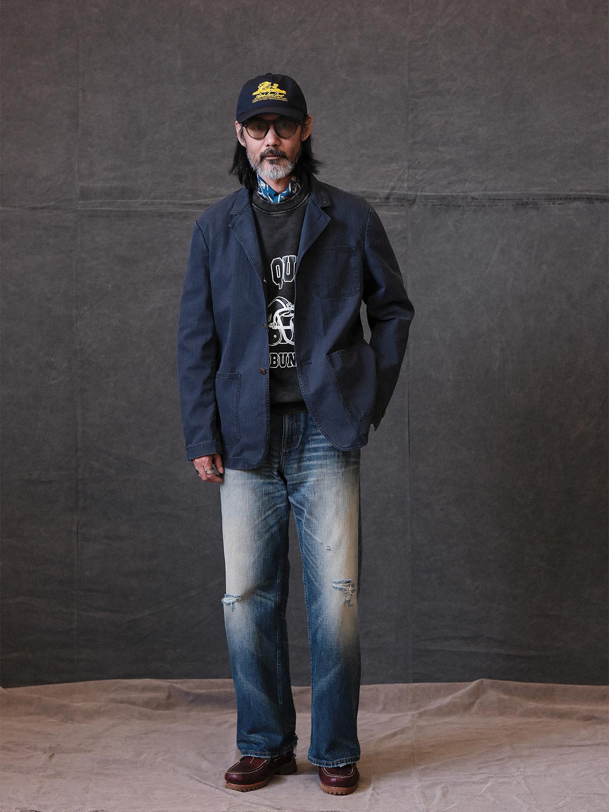 詳細画像: ウォッシュ加工されたヘリンボーン柄の生地とヴィンテージメタルボタンのディテール
モデル画像: ゆるやかなフィットでスタイリッシュなヴィンテージウォッシュジャケットの着用イメージ