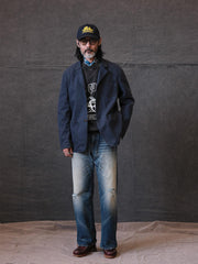 詳細画像: ウォッシュ加工されたヘリンボーン柄の生地とヴィンテージメタルボタンのディテール
モデル画像: ゆるやかなフィットでスタイリッシュなヴィンテージウォッシュジャケットの着用イメージ