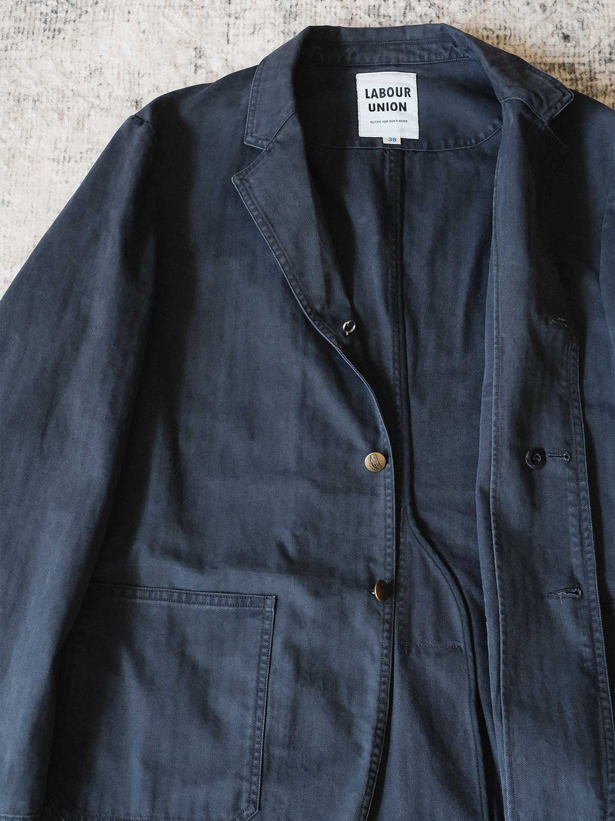 製品画像: ヴィンテージヘリンボーンウォッシュジャケットの全体画像、独特な時代感を持つデザイン
詳細画像: ウォッシュ加工されたヘリンボーン柄の生地とヴィンテージメタルボタンのディテール