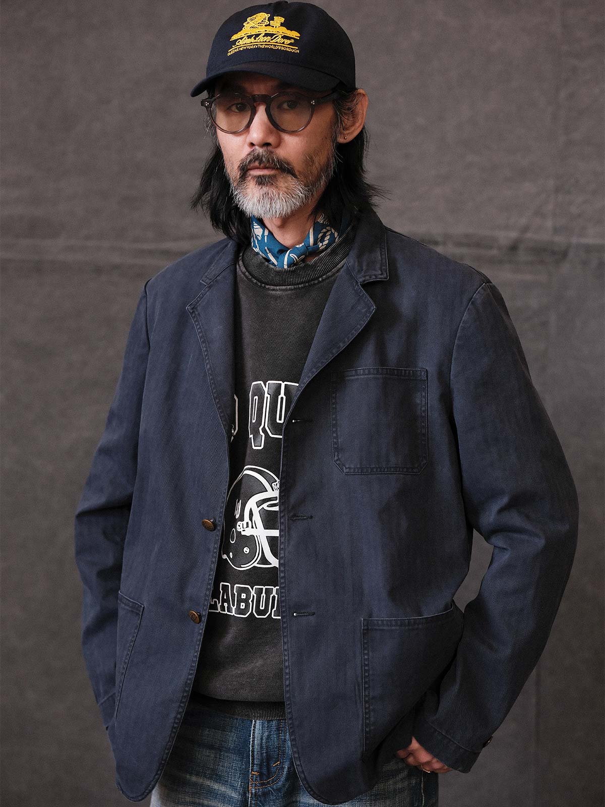 詳細画像: ウォッシュ加工されたヘリンボーン柄の生地とヴィンテージメタルボタンのディテール
モデル画像: ゆるやかなフィットでスタイリッシュなヴィンテージウォッシュジャケットの着用イメージ