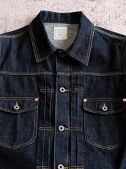 製品画像:
15.5oz生赤耳デニムジャケット全体展示。日本製の赤耳デニム素材を使用したクラシックなデザインで、レトロ感が溢れ、着心地も抜群。
詳細画像:
赤耳部分のディテールと金属ボタンのクローズアップ。伝統的な赤耳処理とクラシックな金属ボタンがヴィンテージスタイルを際立たせます。